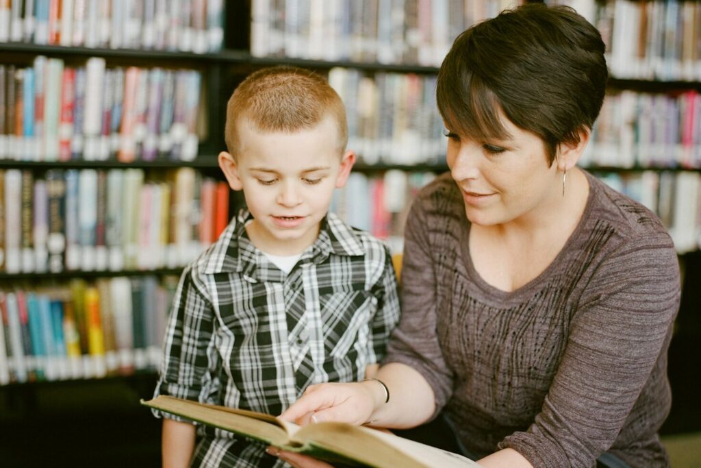 boy in gray sweater beside boy in gray and white plaid dress shirt